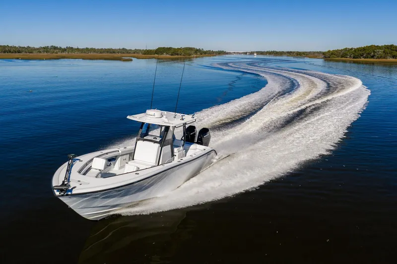 Slide: The Image of 2023 Yellowfin 32 Offshore boat cruising on a calm lake, leaving a wake trail. - 19