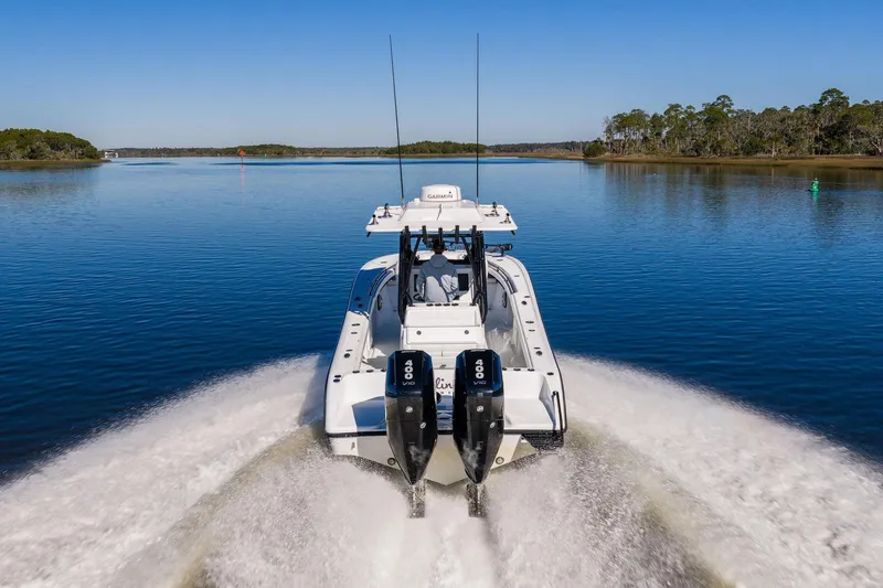Slide: The Image of 2023 Yellowfin 32 Offshore boat cruising on a calm lake with twin engines. - 23