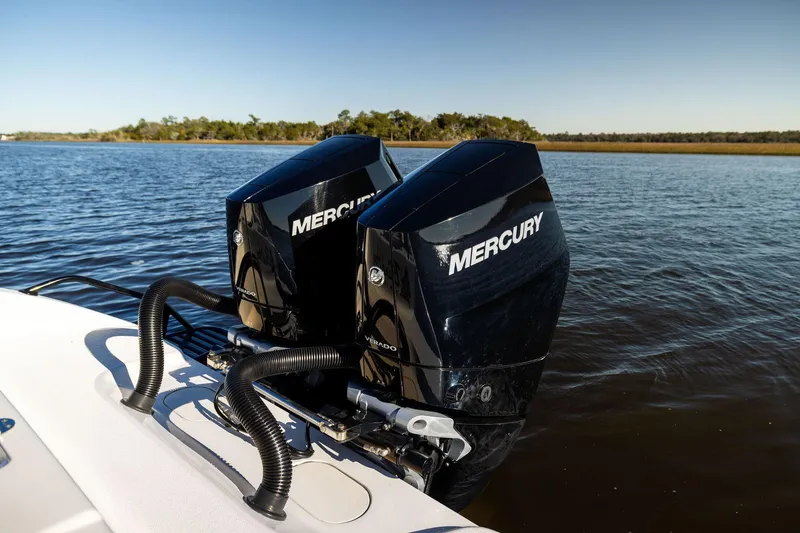 Slide: The Image of Twin Mercury outboard engines on a 2023 Yellowfin 32 Offshore boat, cruising on calm waters. - 28