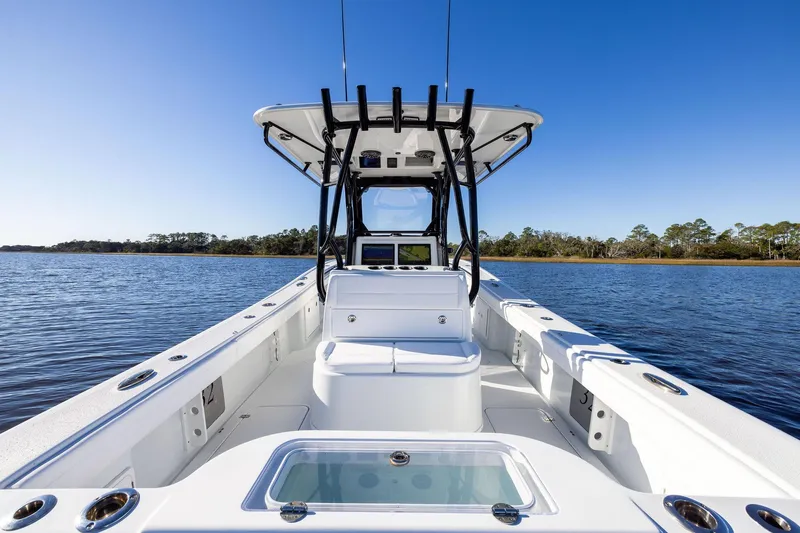 Slide: The Image of 2023 Yellowfin 32 Offshore boat on calm water, clear blue sky background. - 29