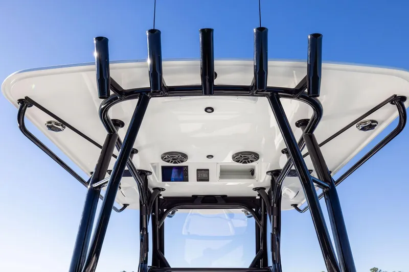 Slide: The Image of 2023 Yellowfin 32 Offshore boat's T-top with rod holders and speakers against blue sky. - 30