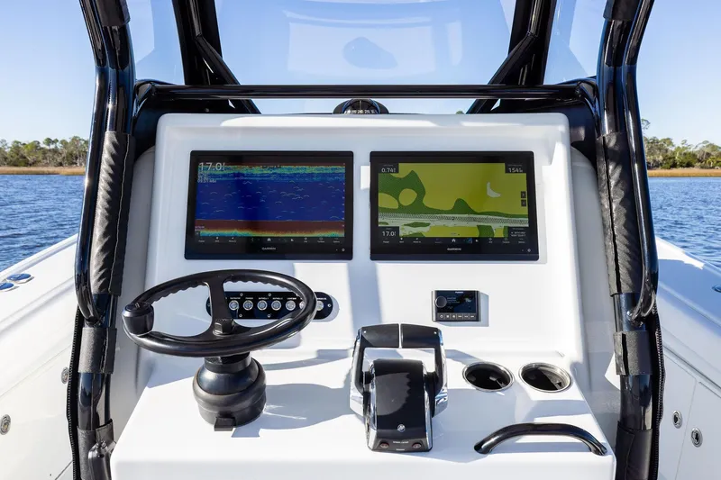 Slide: The Image of 2023 Yellowfin 32 Offshore boat dashboard with dual navigation screens and steering wheel. - 35
