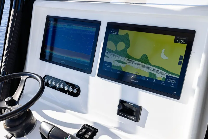 Slide: The Image of 2023 Yellowfin 32 Offshore boat dashboard with dual Garmin displays and controls. - 37