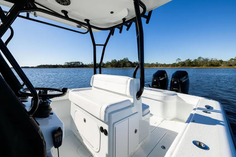 Slide: The Image of 2023 Yellowfin 32 Offshore boat interior with dual engines on a calm lake. - 42