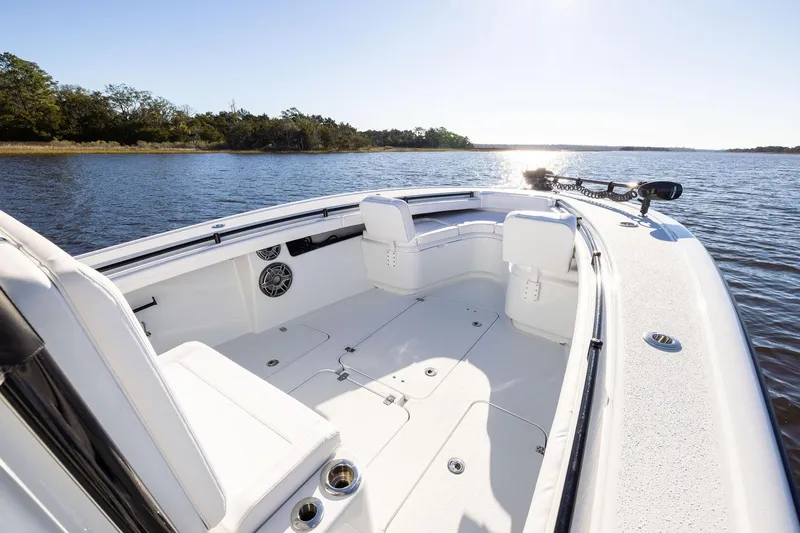 Slide: The Image of 2023 Yellowfin 32 Offshore boat on serene water, showcasing spacious deck and seating. - 48