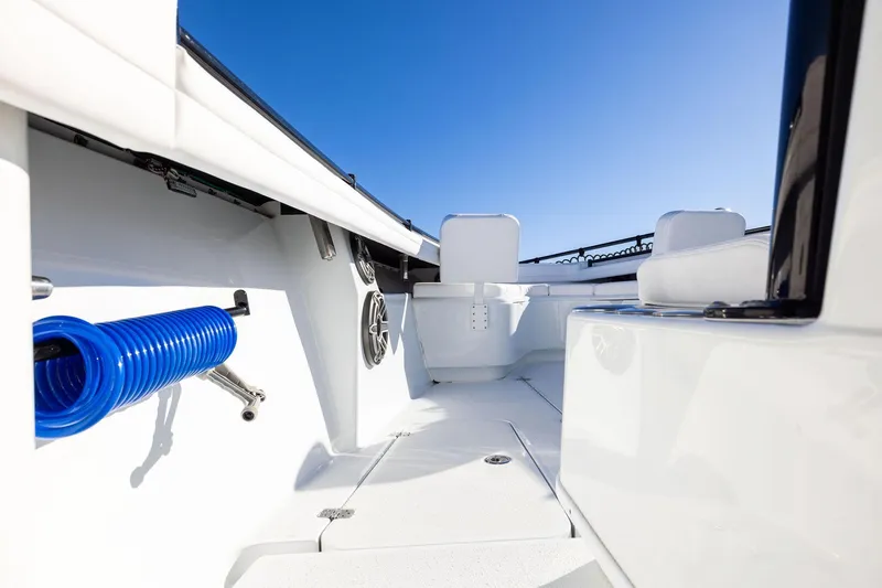 Slide: The Image of 2023 Yellowfin 32 Offshore boat interior with seating and blue hose. - 56