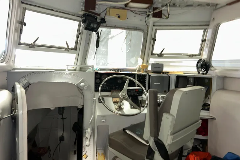 Slide: The Image of Interior of a 1963 Motor Life Boat 44, featuring steering wheel and navigation equipment. - 11