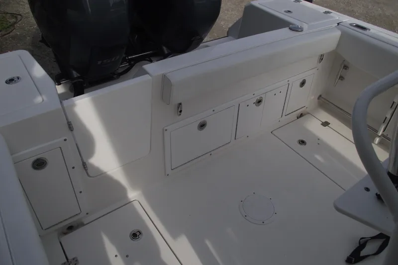 Slide: The Image of 2019 Edgewater 245CC boat deck with storage compartment and latch. - 32