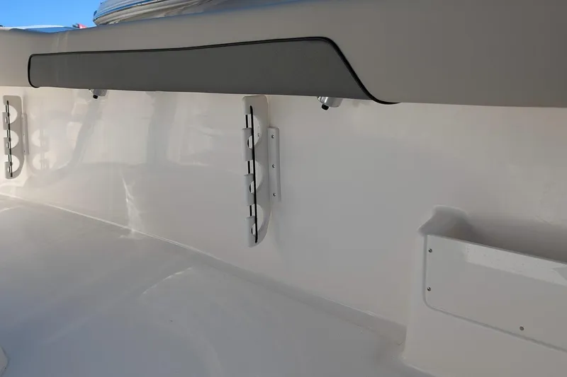 Slide: The Image of 2026 Key West 239 FS boat interior detail with rod holders and cushioned panel. - 13