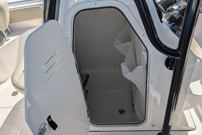 Slide: The Image of 2026 Key West 239 FS boat interior storage compartment with open door. - 18