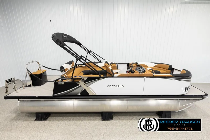 The Image of 2026 Avalon LSZ CRB pontoon boat with tan seating and black canopy in showroom. - 1