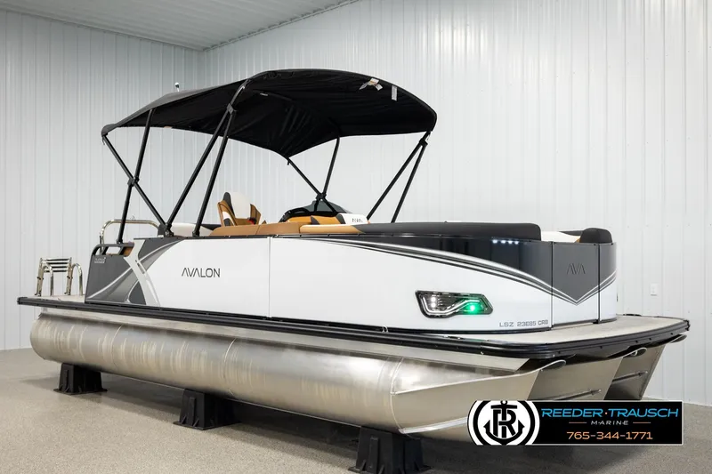 Slide: The Image of 2026 Avalon LSZ CRB pontoon boat with canopy in showroom display. - 3