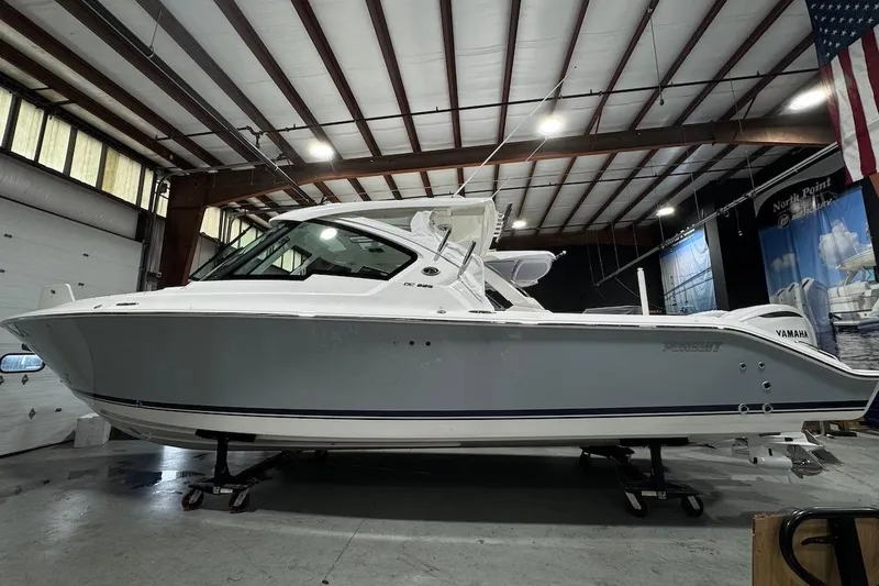 The Image of 2026 Pursuit DC 326 Dual Console boat in indoor showroom setting. - 0
