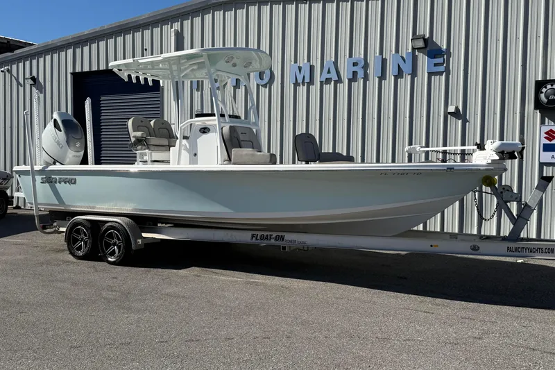 The Image of 2022 Sea Pro 248 Bay boat on trailer outside marine shop. - 1