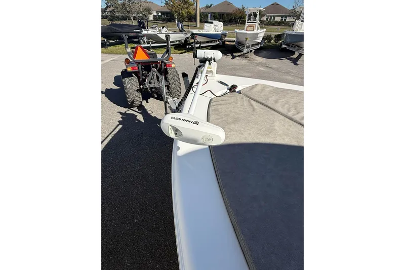 Slide: The Image of 2022 Sea Pro 248 Bay boat with Minn Kota trolling motor, parked near a tractor. - 12