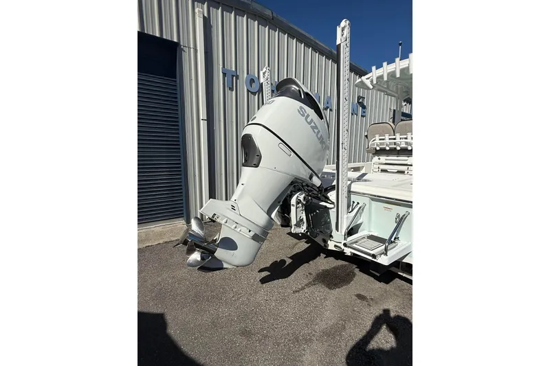 Slide: The Image of 2022 Sea Pro 248 Bay boat with Suzuki outboard motor, parked outside a building. - 4