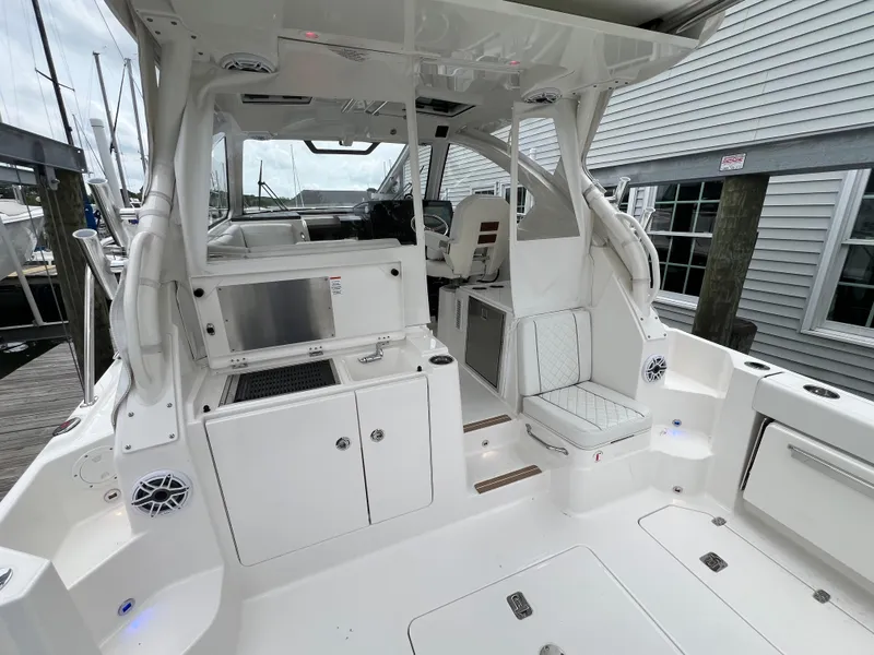 Slide: The Image of 2025 Pursuit OS 325 Offshore boat interior, featuring sleek white design and modern amenities. - 13