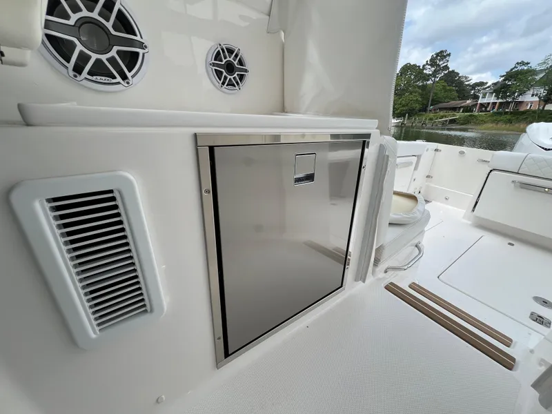 Slide: The Image of 2025 Pursuit OS 325 Offshore boat interior with stainless steel storage and speakers. - 18