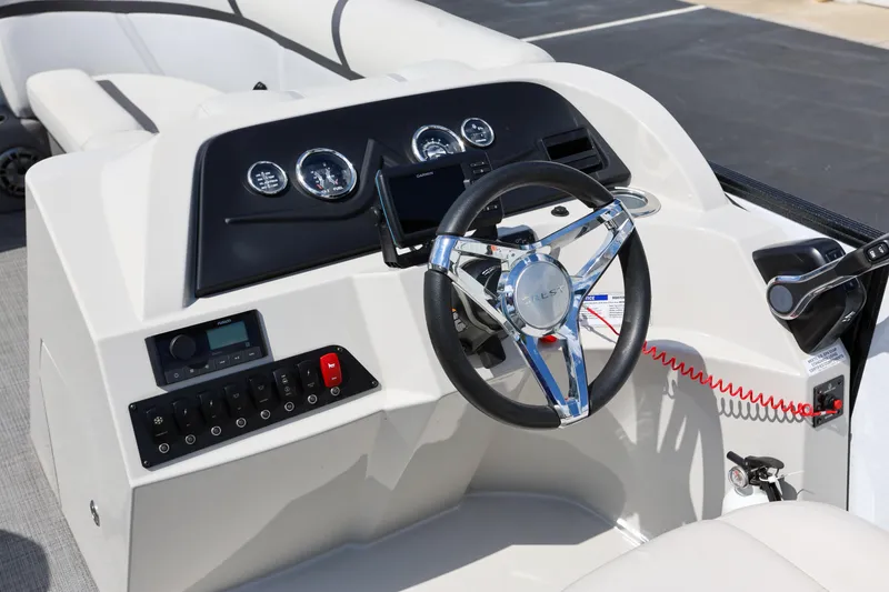 Slide: The Image of 2023 Crest Classic LX 220 SLC boat dashboard with steering wheel and controls. - 12