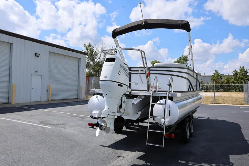 Slide: The Image of 2023 Crest Classic LX 220 SLC pontoon boat with outboard motor in parking lot. - 2