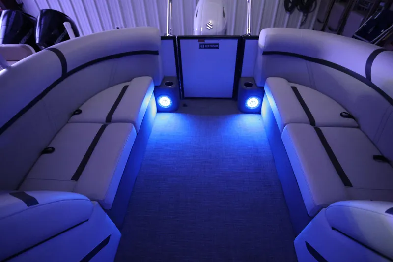 Slide: The Image of 2023 Crest Classic LX 220 SLC boat interior with blue LED lighting and cushioned seating. - 20
