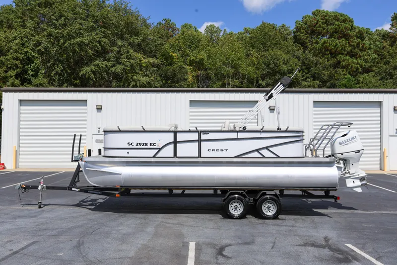 Slide: The Image of 2023 Crest Classic LX 220 SLC pontoon boat on trailer, parked outdoors. - 5