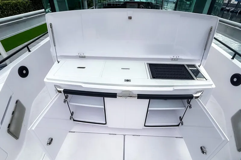 Slide: The Image of Outdoor kitchen on 2023 Axopar 37 XC Cross Cabin boat, featuring grill and storage compartments. - 10