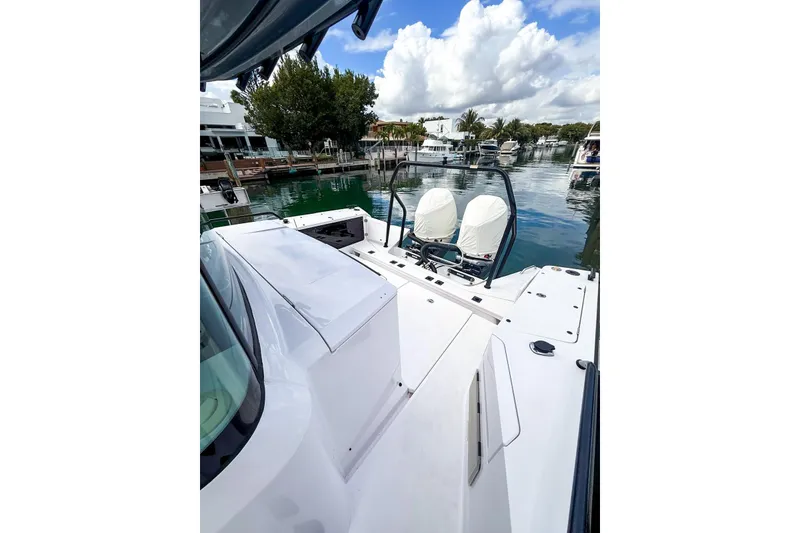 Slide: The Image of 2023 Axopar 37 XC Cross Cabin boat docked in a scenic marina. - 16