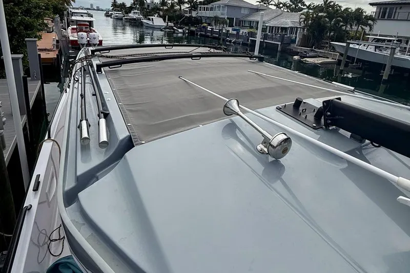 Slide: The Image of 2023 Axopar 37 XC Cross Cabin boat docked in a scenic marina setting. - 17
