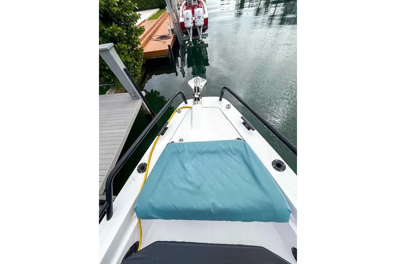 Slide: The Image of 2023 Axopar 37 XC Cross Cabin boat docked, featuring a teal cushion and sleek design. - 18