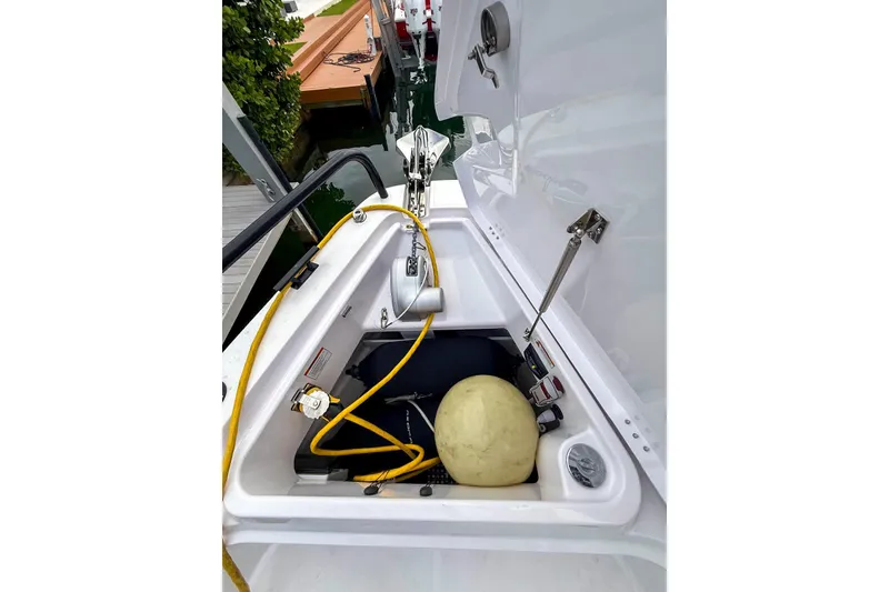 Slide: The Image of 2023 Axopar 37 XC Cross Cabin storage compartment with equipment and yellow rope. - 19