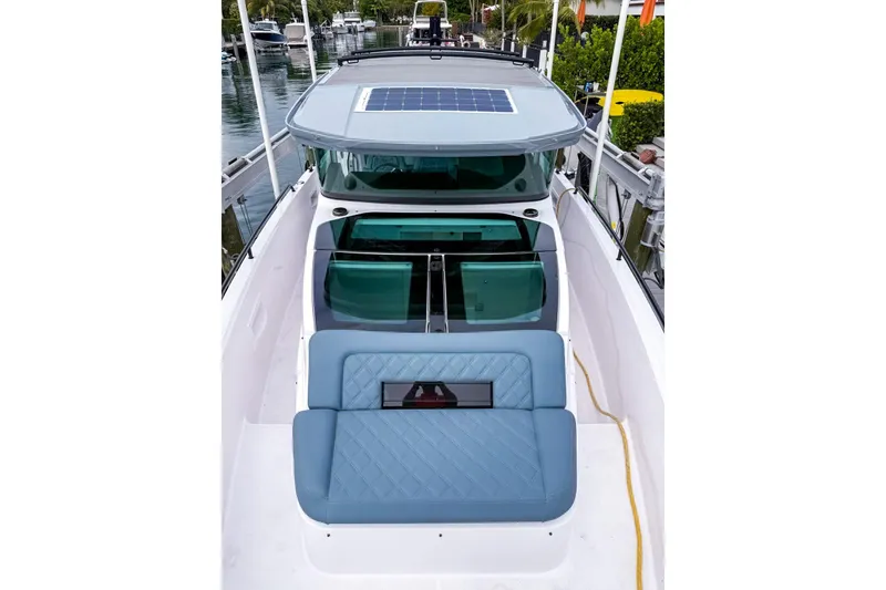 Slide: The Image of 2023 Axopar 37 XC Cross Cabin boat with blue seating and solar panel roof. - 21