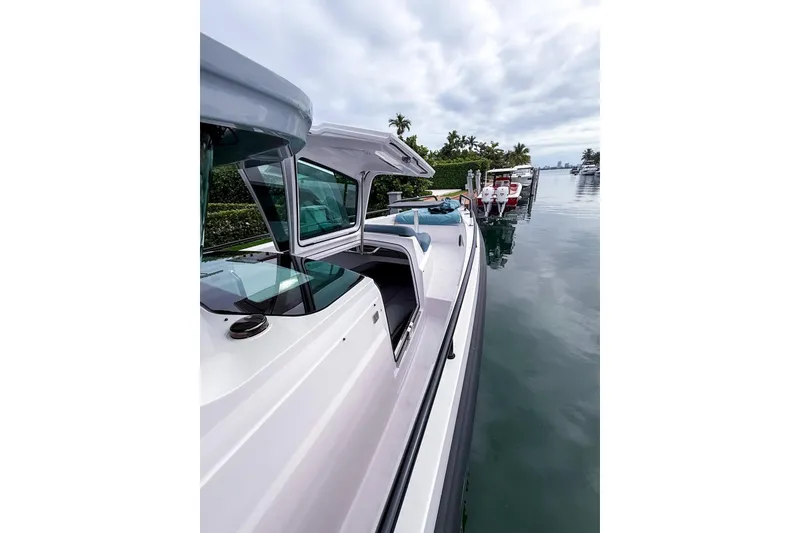 Slide: The Image of 2023 Axopar 37 XC Cross Cabin docked on a calm waterfront. - 24