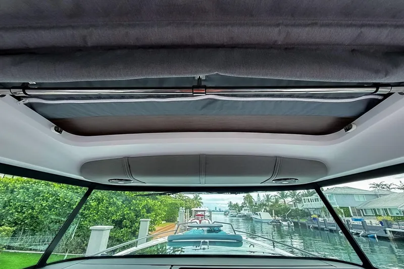 Slide: The Image of Interior view of 2023 Axopar 37 XC Cross Cabin, showcasing sunroof and canal scenery. - 26
