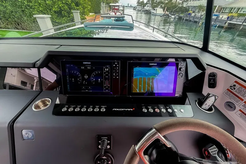Slide: The Image of 2023 Axopar 37 XC Cross Cabin dashboard with navigation screens and controls. - 28