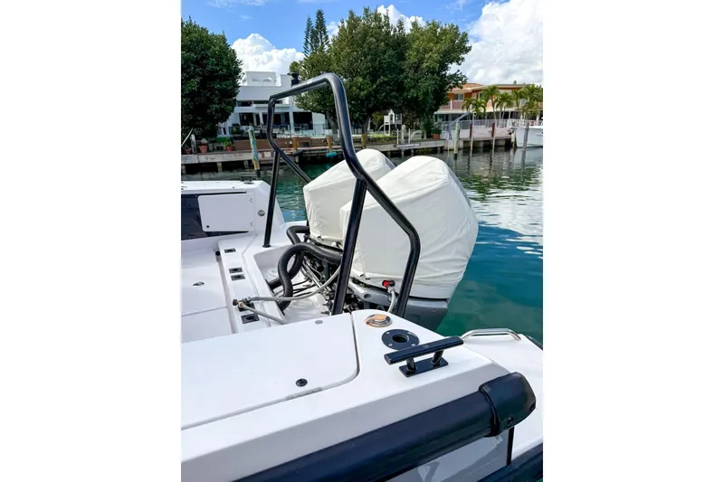 Slide: The Image of 2023 Axopar 37 XC Cross Cabin boat with covered outboard motor, docked by waterfront homes. - 3