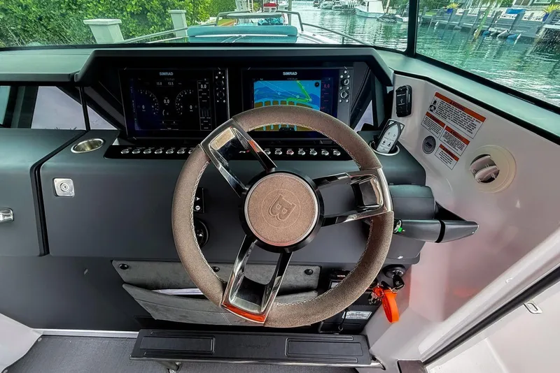 Slide: The Image of 2023 Axopar 37 XC Cross Cabin helm with modern steering and navigation displays. - 31