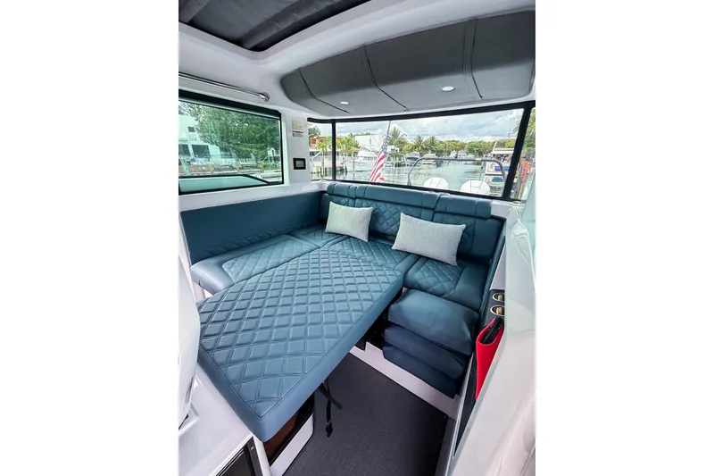 Slide: The Image of 2023 Axopar 37 XC Cross Cabin interior with blue quilted seating and cushions. - 37