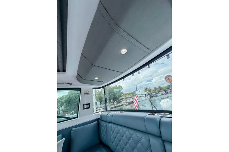 Slide: The Image of Interior view of 2023 Axopar 37 XC Cross Cabin with quilted seating and window view. - 46