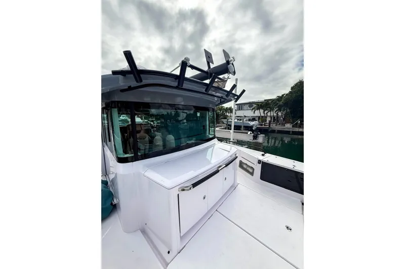 Slide: The Image of 2023 Axopar 37 XC Cross Cabin boat docked, showcasing sleek design and modern features. - 9
