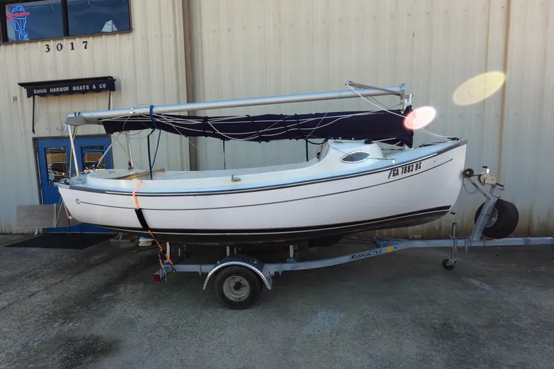 Slide: The Image of 2023 Com-Pac Sunday Cat sailboat on trailer outside Snug Harbor Boats & Co. - 1