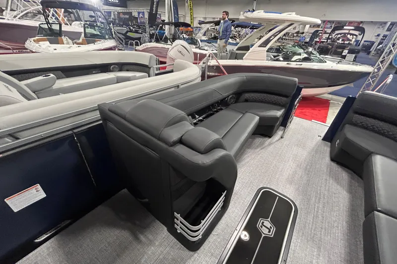 Slide: The Image of 2026 Harris Grand Mariner 250 interior with luxurious seating at a boat show. - 2