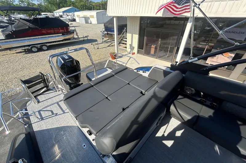 Slide: The Image of 2026 Harris Grand Mariner 250 pontoon boat with seating and outboard motor in a marina. - 22