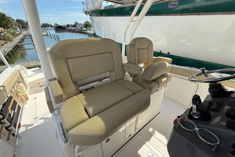 Slide: The Image of 2021 Pursuit S 328 Sport boat interior with beige seating and steering console. - 3