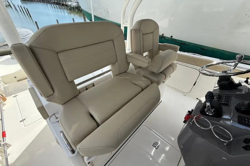 Slide: The Image of 2021 Pursuit S 328 Sport boat interior with beige seating and steering console. - 8