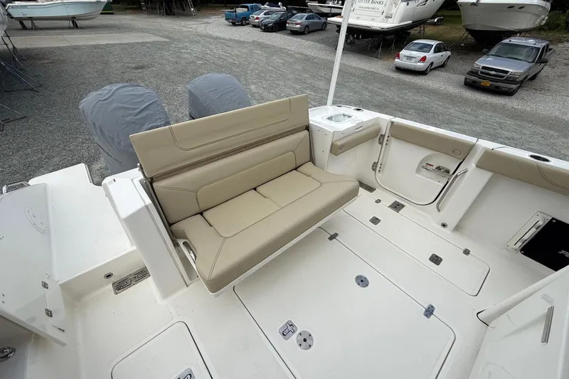 Slide: The Image of 2021 Pursuit S 328 Sport boat interior with beige seating and storage compartments. - 9