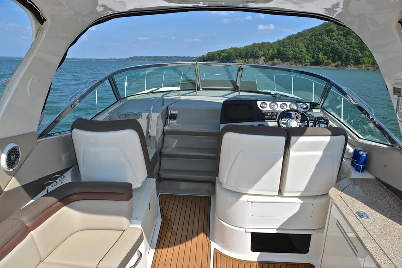 Slide: The Image of 2016 Sea Ray Sundancer 370 interior with helm, seating, and scenic water view. - 19