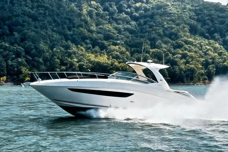Slide: The Image of 2016 Sea Ray Sundancer 370 cruising on a scenic lake with lush green hills. - 2