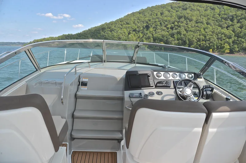 Slide: The Image of 2016 Sea Ray Sundancer 370 cockpit with modern controls, cruising on a scenic lake. - 23