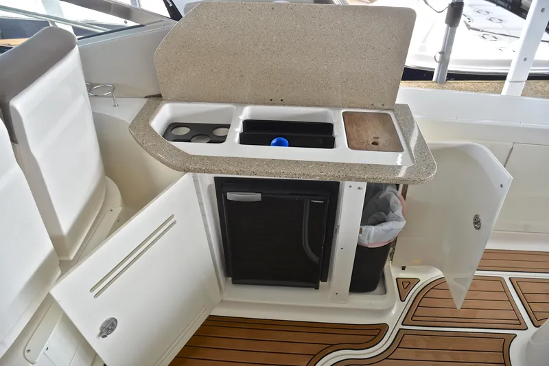 Slide: The Image of 2016 Sea Ray Sundancer 370 boat kitchenette with sink, fridge, and storage cabinets. - 27